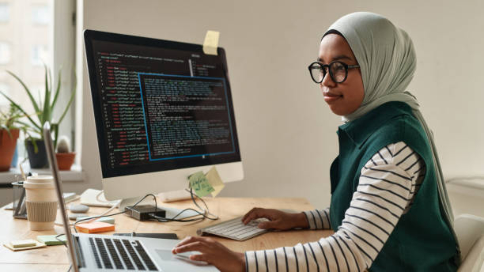 Side view of young intern or professional software developer touching laptop touchpad while looking through online information
